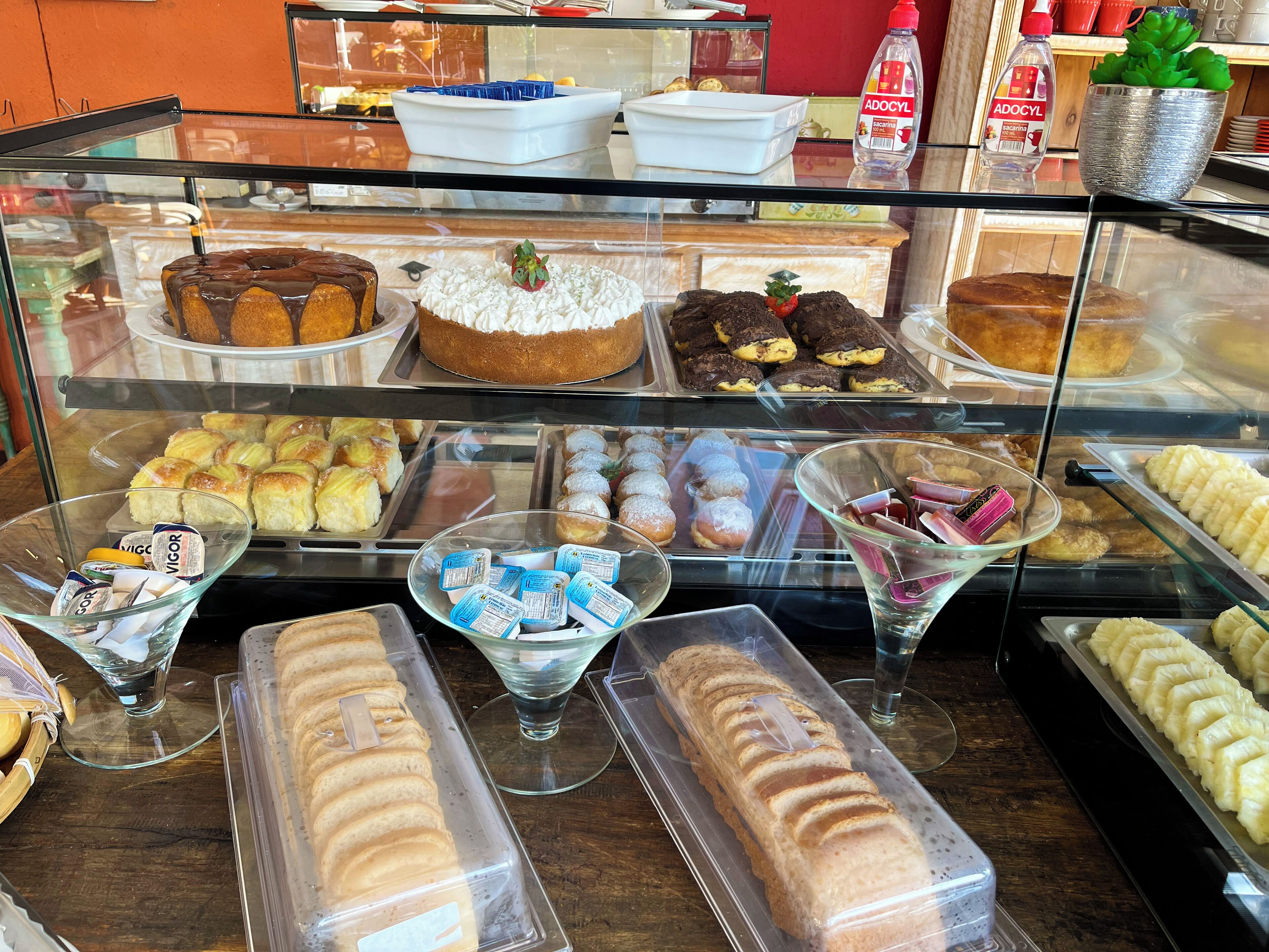 Une vitrine de boulangerie où sont exposés divers produits de boulangerie, notamment des gâteaux, des pâtisseries et du pain.