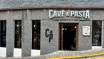 A building facade with a sign reading "CAVE & PASTA" and a menu board on the right.