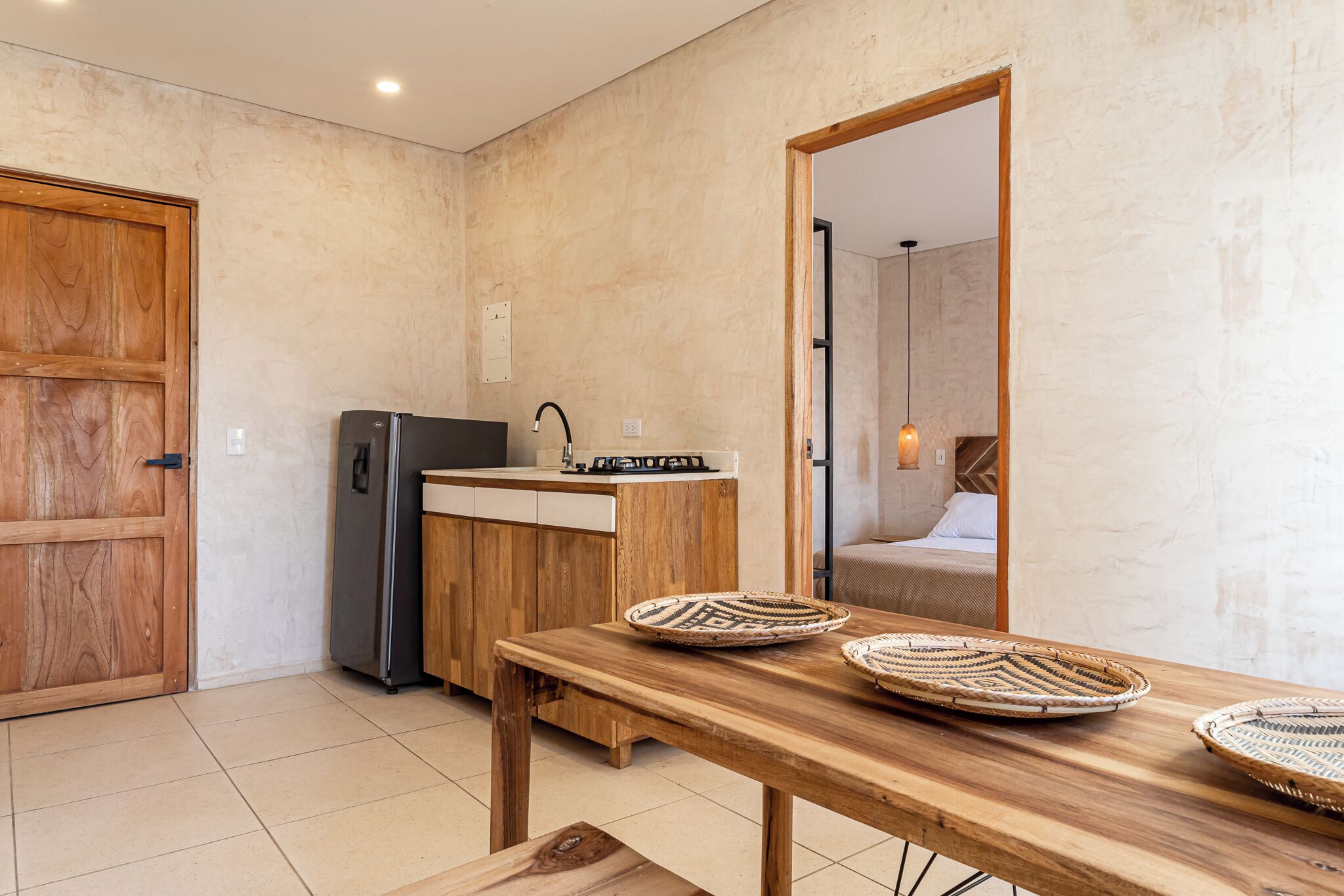 A compact kitchen with a wooden table, a refrigerator, and a sink.