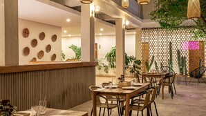 A restaurant with wooden tables and chairs, a counter with a menu, and decorative wall art. - Soy Local Santa Marta  (Santa Marta)