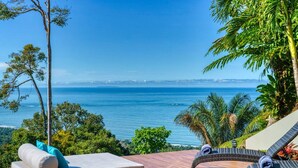 A wooden deck with a lounge chair and a cushioned bench overlooking a coastal view. - Casa Privado - Hermosa Resort Villa #4 Costa Rica (Uvita)