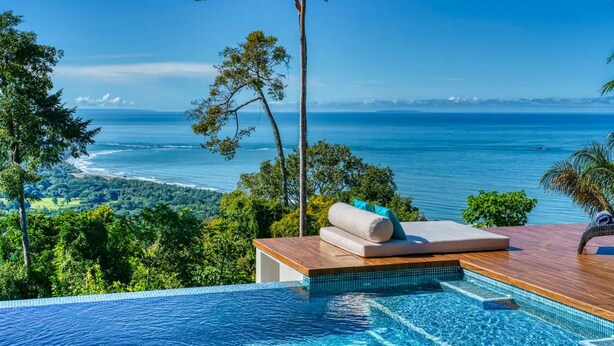 An infinity pool with a wooden deck and a view of the ocean. - Casa Privado - Hermosa Resort Villa #4 Costa Rica (Uvita)