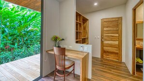 A compact room with a wooden desk and chair, a built-in bookshelf, and a sliding door leading to a closet. - Casa Privado - Hermosa Resort Villa #4 Costa Rica (Uvita)