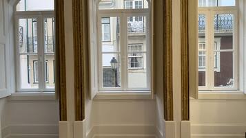 A room with three large arched windows, white walls, and a patterned floor.