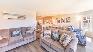 A living room with two sofas, a dining area, and a kitchen in the background. - Amazing Ocean Views, Pets Ok, Walk To Town and Beach (Breeze) (Long Beach)