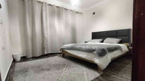 Une chambre à coucher avec un lit, des rideaux et un tapis.
