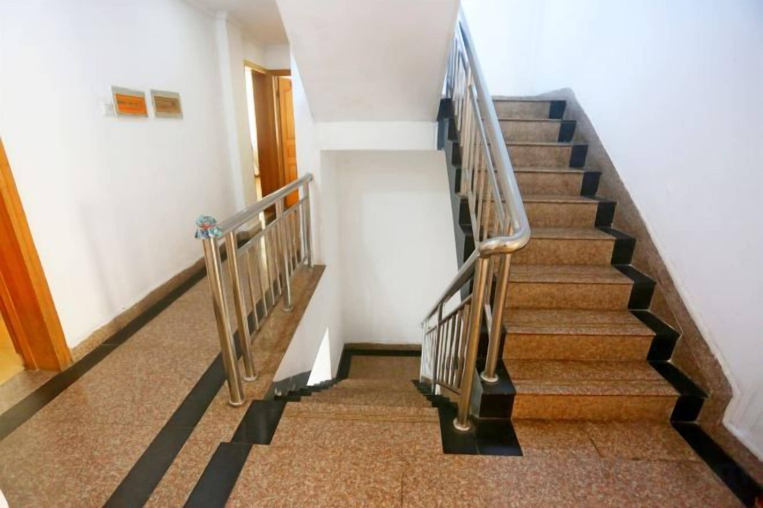 A staircase with metal railings and a carpeted floor.