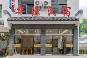 Ein Hotel im traditionellen chinesischen Baustil, mit einem Ziegeldach und großen Glasfenstern.