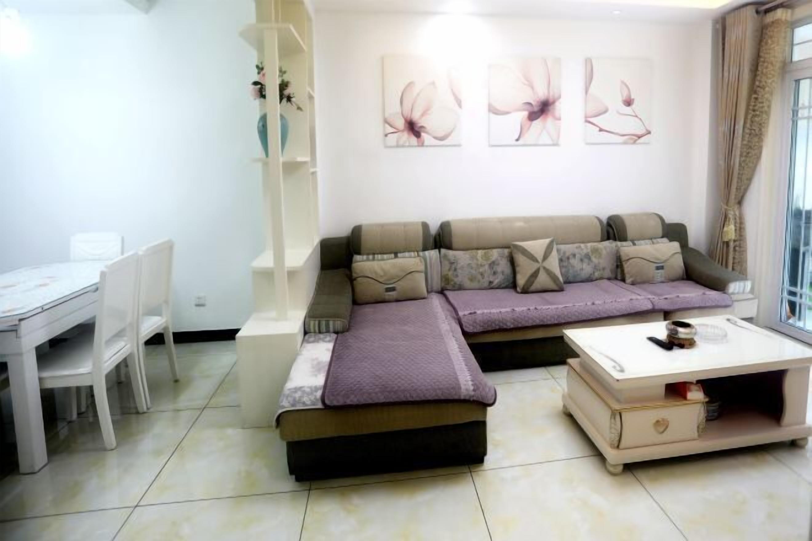 Una sala de estar moderna con un sofá modular, una mesa de centro y un comedor con sillas y una mesa.