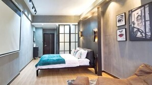 A modern hotel room with a bed, a seating area, and artwork on the walls. - Huayuan Homestay (Huangshang Scenic Area South Gate) (Huangshan City)