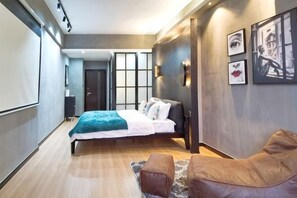 A modern hotel room with a bed, a seating area, and artwork on the walls. - Huayuan Homestay (Huangshang Scenic Area South Gate) (Huangshan City)
