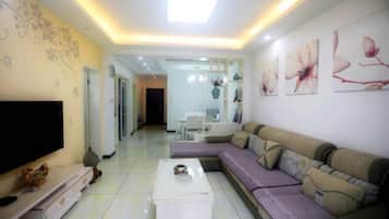 A modern living room with a sofa, a coffee table, a TV, and decorative wall art.