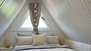 Ein Schlafzimmer mit einem großen Bett, einem Fenster mit Vorhängen und einem Teppich.