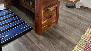 Una cucina con isola in legno, una finestra e un tappeto.