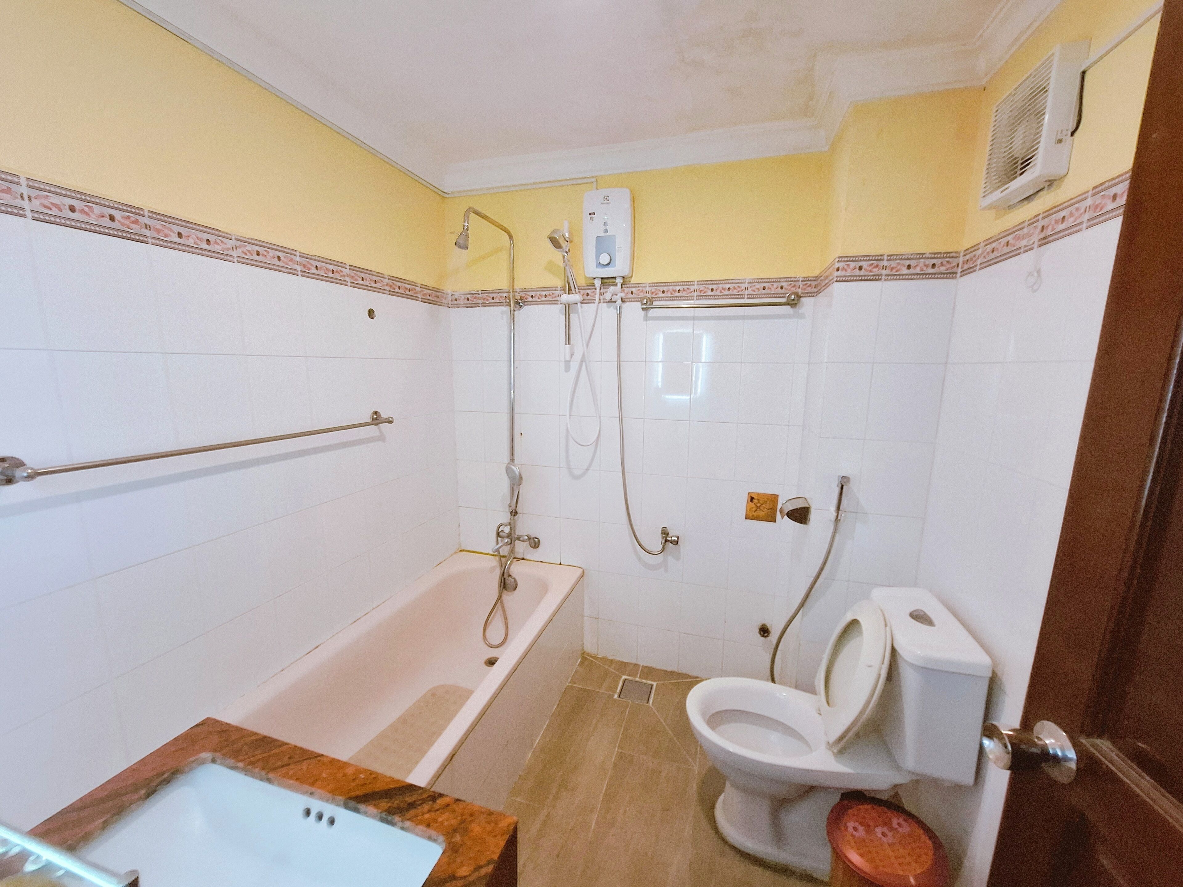 A bathroom with a bathtub, toilet, and shower.