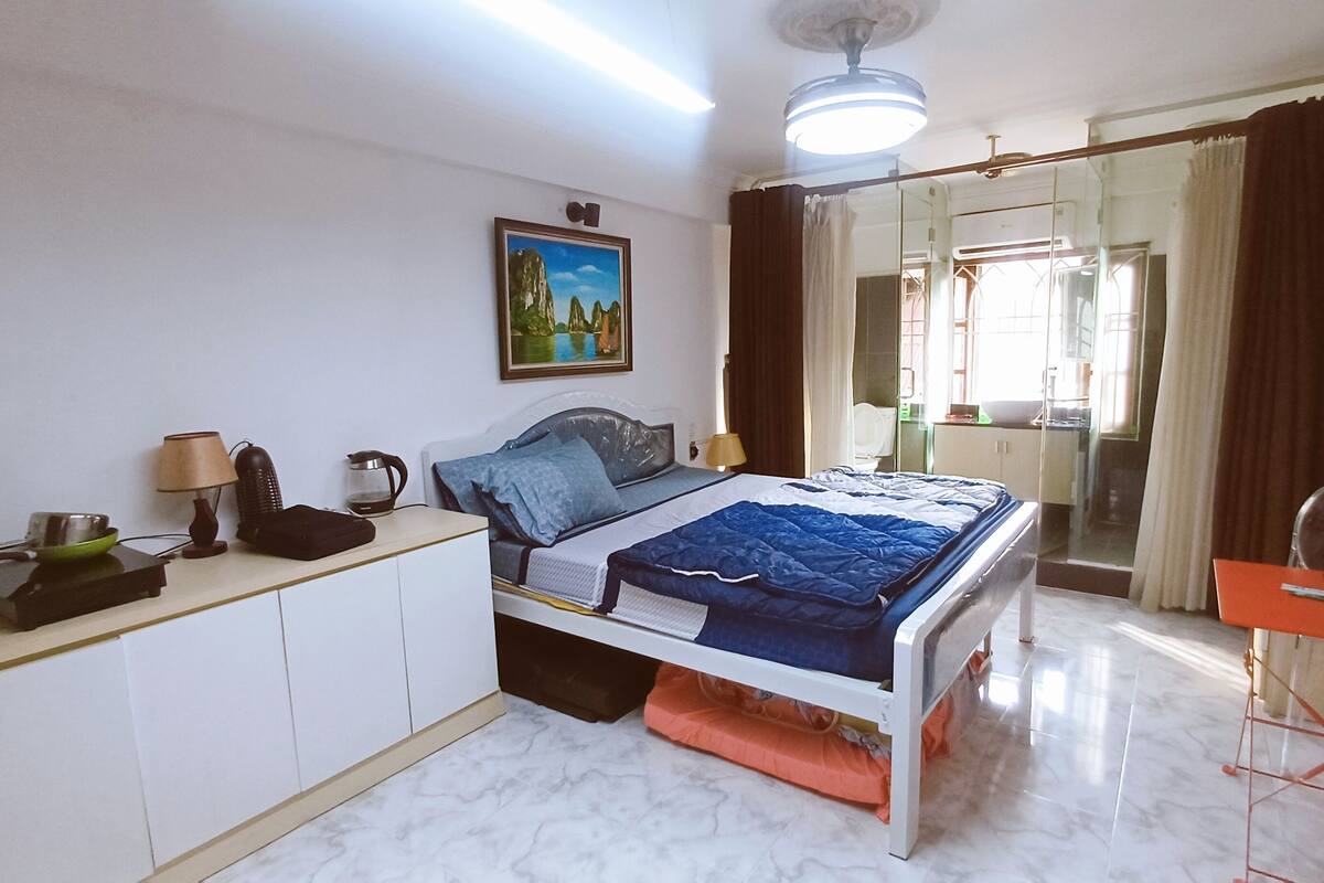 Une chambre à coucher avec un lit, une table de chevet, une lampe et un tableau au mur.