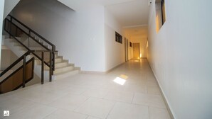 Un pasillo amplio con una escalera a la izquierda que da a una distribución.