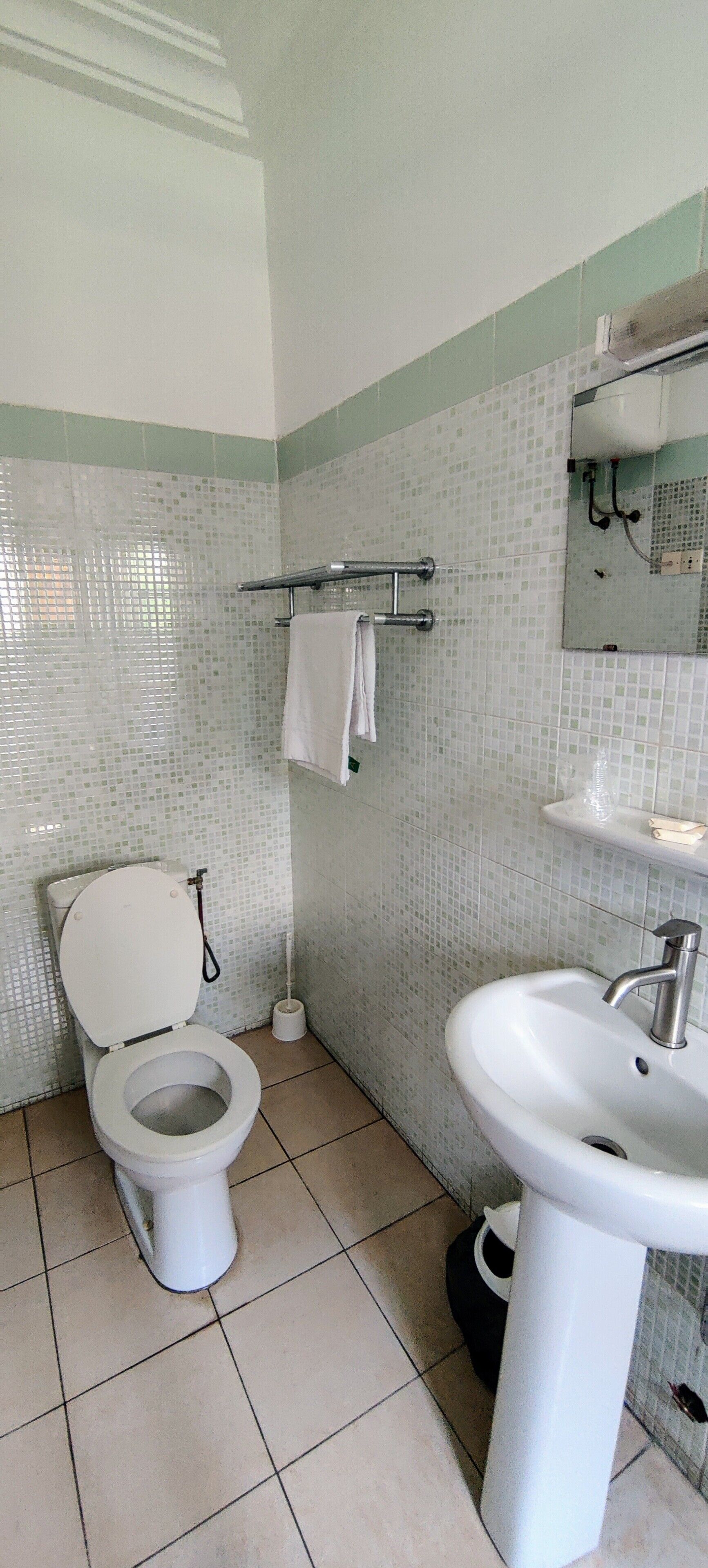 Ein Badezimmer mit Toilette, Waschbecken und Fliesen.