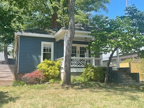 A residential house with a front porch, a chimney, and a small garden area.