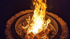 Un foyer circulaire, avec des bûches et des flammes.