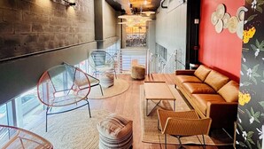 A modern interior with a wooden floor, a red accent wall, and a seating area with a sofa and chairs. - Smart Brickell Hotel (Miami)