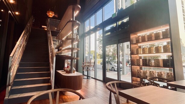 A modern interior with a staircase, wooden tables, and chairs, and a view of the street outside. - Smart Brickell Hotel (Miami)