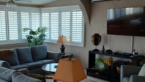 A living room with a sofa, a coffee table, a lamp, a TV, and a plant. - Romantic Villa Beach House (San Carlos)