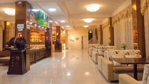 Een hotel lobby met zithoeken, een receptiebalie en een bar.