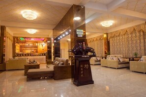 Eine Lobby mit einer Rezeption, einer Sitzecke und einer Bar.