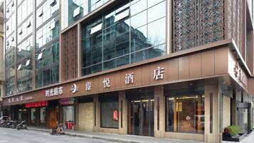 A hotel with a modern facade, large glass windows, and a prominent signage.