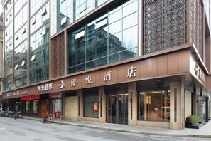 A hotel with a modern facade, large glass windows, and a prominent signage. - Zhenyue Hotel (Shanghai)