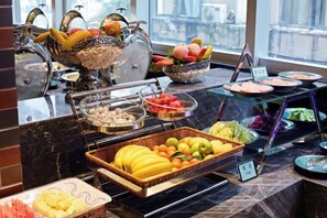 Un buffet proposant une variété de fruits, de légumes et de viandes.
