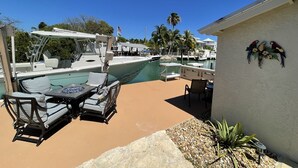 A marina with boats, a pool, and outdoor seating. - BEST House in Marathon With Ocean View! (Marathon)