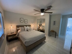 A bedroom with a bed, nightstands, a ceiling fan, and a mirror. - BEST House in Marathon With Ocean View! (Marathon)