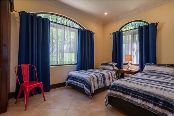 A room with two beds, a chair, and a window with curtains. - Great Ocean View and easy access (Savegre de Aguirre)