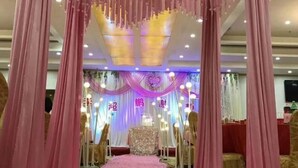 Un escenario con cortinas rosadas y un fondo floral.
