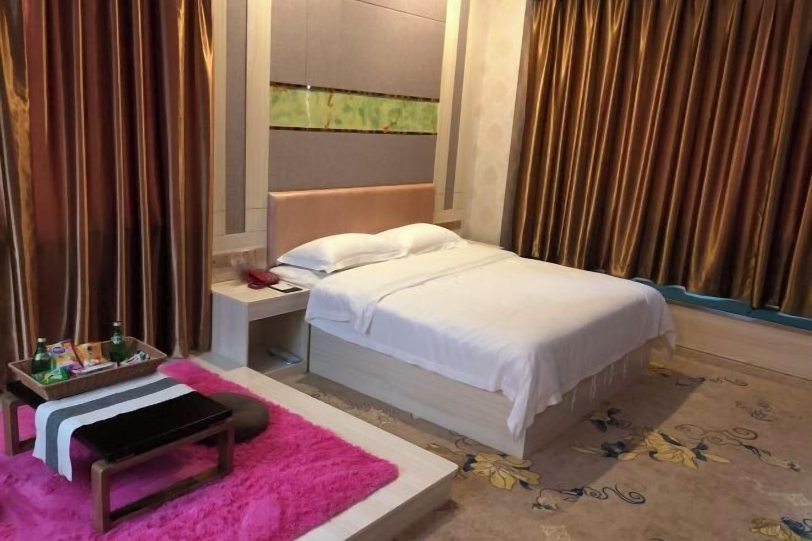 A bedroom with a bed, bedside table, and a small bench.