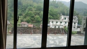 A view through a window with a view of a construction site and buildings in the background. - Xifengkezhan (Wuyuan)