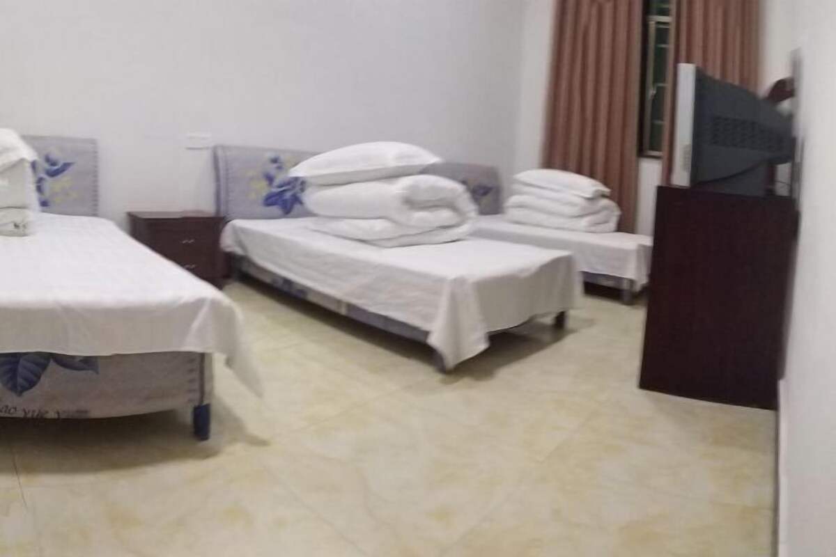 A hotel room with two beds, a small table, and a television.