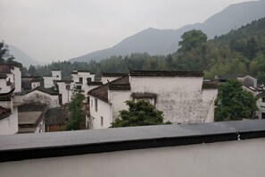 Traditional architecture with white walls and tiled roofs, surrounded by greenery and mountains. - Xifengkezhan (Wuyuan)
