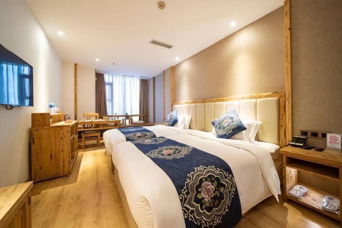 Una habitación de hotel con una cama grande, un escritorio y un televisor.