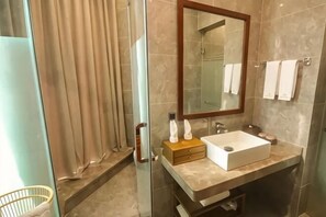 A bathroom with a glass shower enclosure, a sink with a mirror, and a towel rack. - City Cottage Hotel (Chengdu Luomashi Metro Station) (Chengdu)