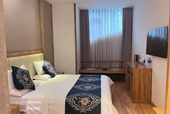 A hotel room with a bed, a TV, a wooden bench, and a window with curtains. - City Cottage Hotel (Chengdu Luomashi Metro Station) (Chengdu)