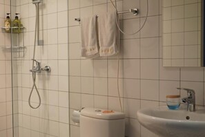 A bathroom with a shower, toilet, sink, and towel rack. - City Cottage Hotel (Chengdu Luomashi Metro Station) (Chengdu)
