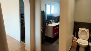 A modern bathroom with a toilet, sink, and mirror. There is a wooden floor and a view of a kitchen area through an open doorway. - South-facing, pleasant, quiet 65 ㎡ (Montpellier)