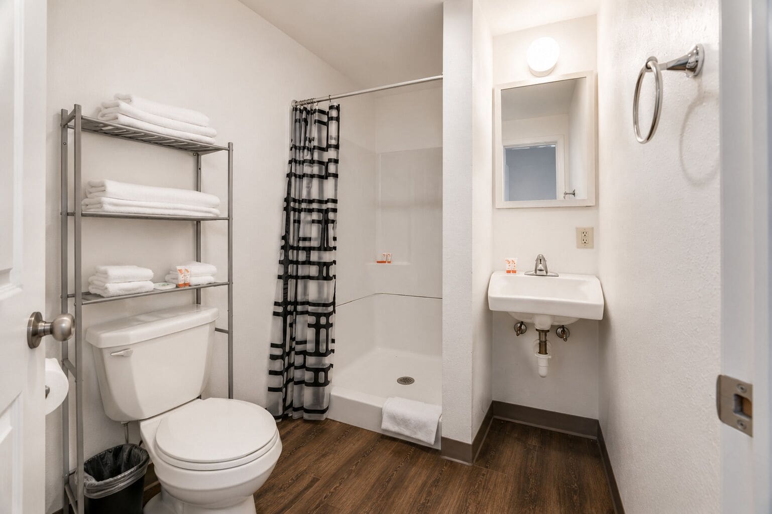 Een badkamer met toilet, douche, wastafel en handdoekhouder.