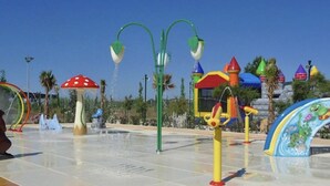 Ein Wasserpark mit verschiedenen Spielbereichen, darunter eine Rutsche und eine Wassersäule.