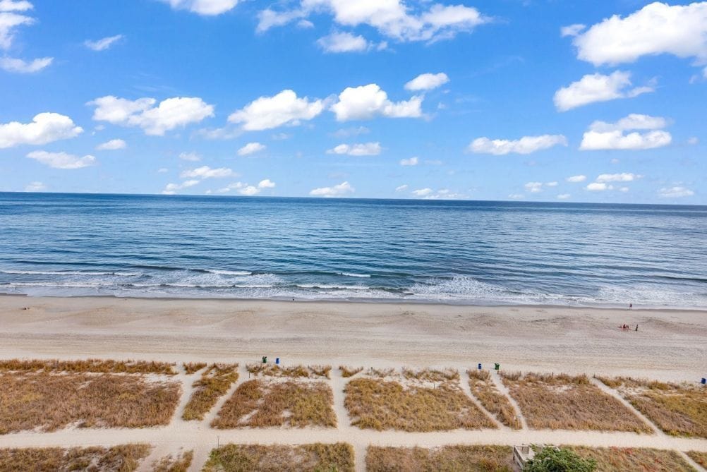 A beach with a clear sky and calm sea.