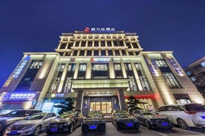 A multi-story hotel with a prominent entrance and several parked cars in front. - Jialida Hotel (Guangzhou)