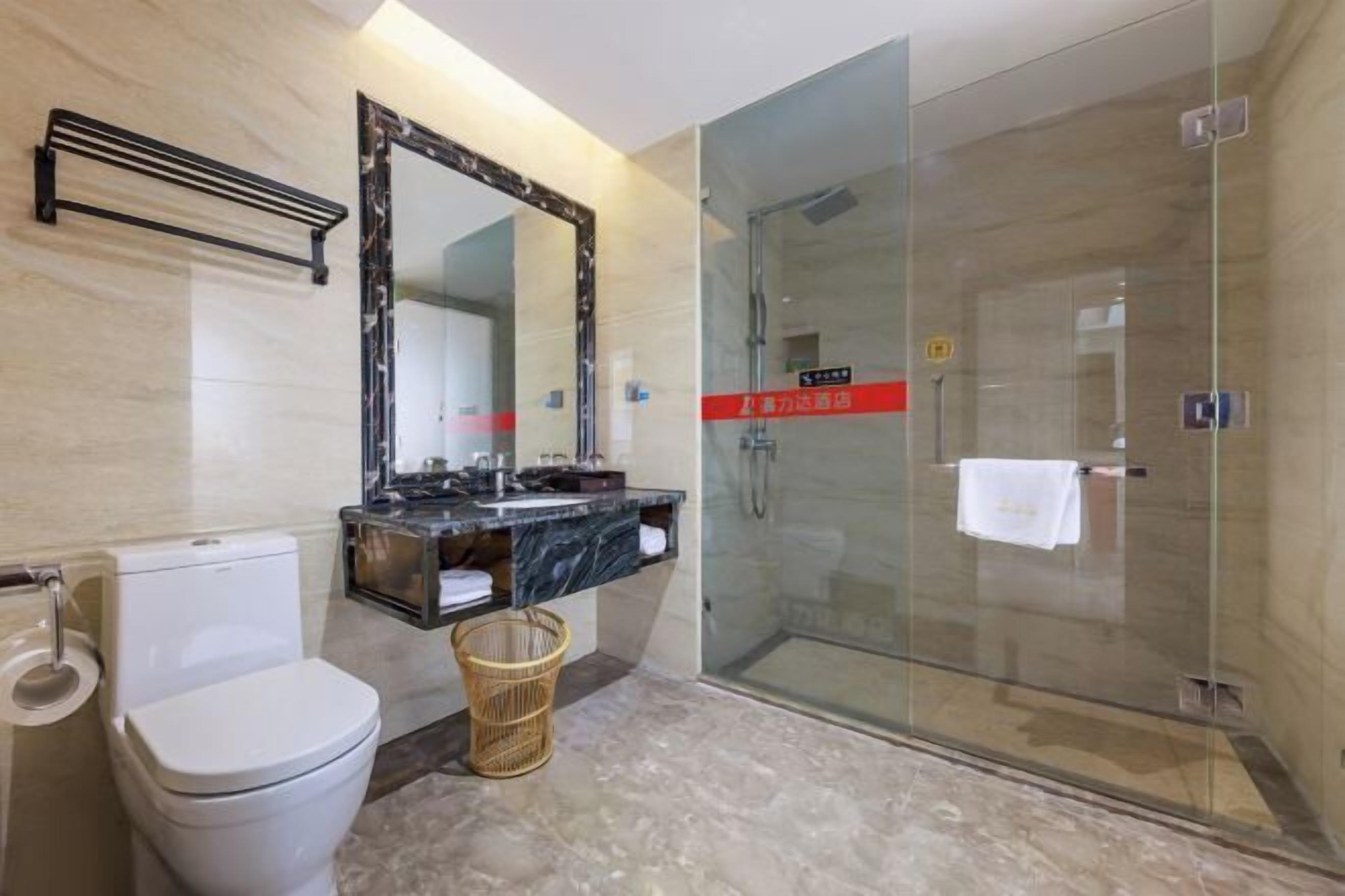 Ein modernes Badezimmer mit Duschkabine aus Glas, Marmorwaschtisch und Toilette.
